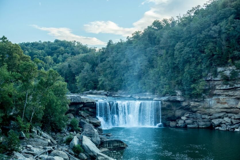 waterfalls in the middle of green trees during daytime